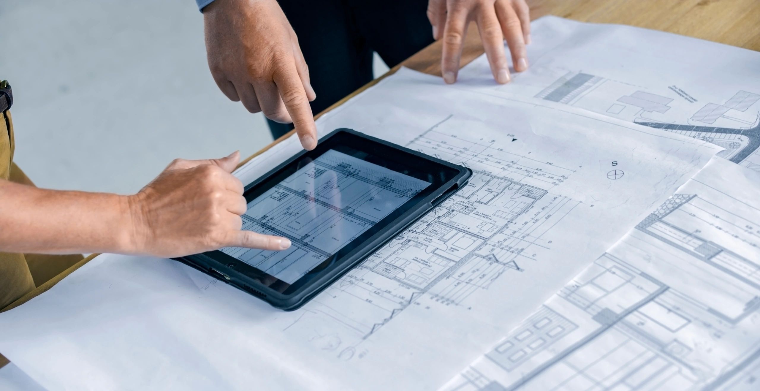 Professional reviewing site compliance plans on a tablet at an industrial facility